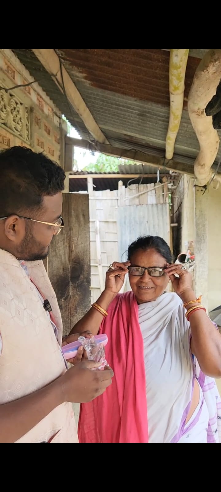 An elderly woman trying on her new spectacles received under Kalyan Kiran